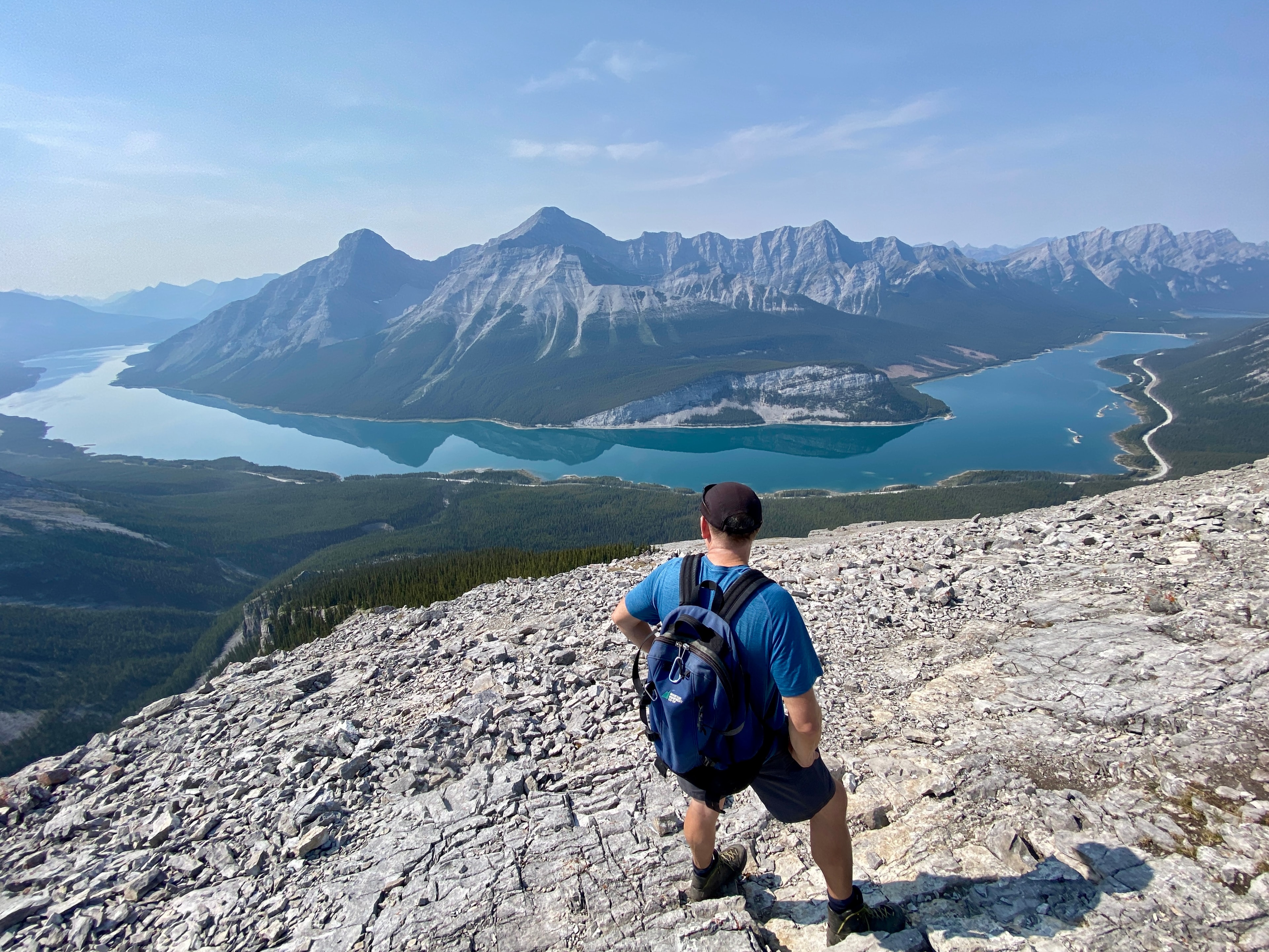 Hiker overlooking turquoise lake and mountains in the Canadian Rockies