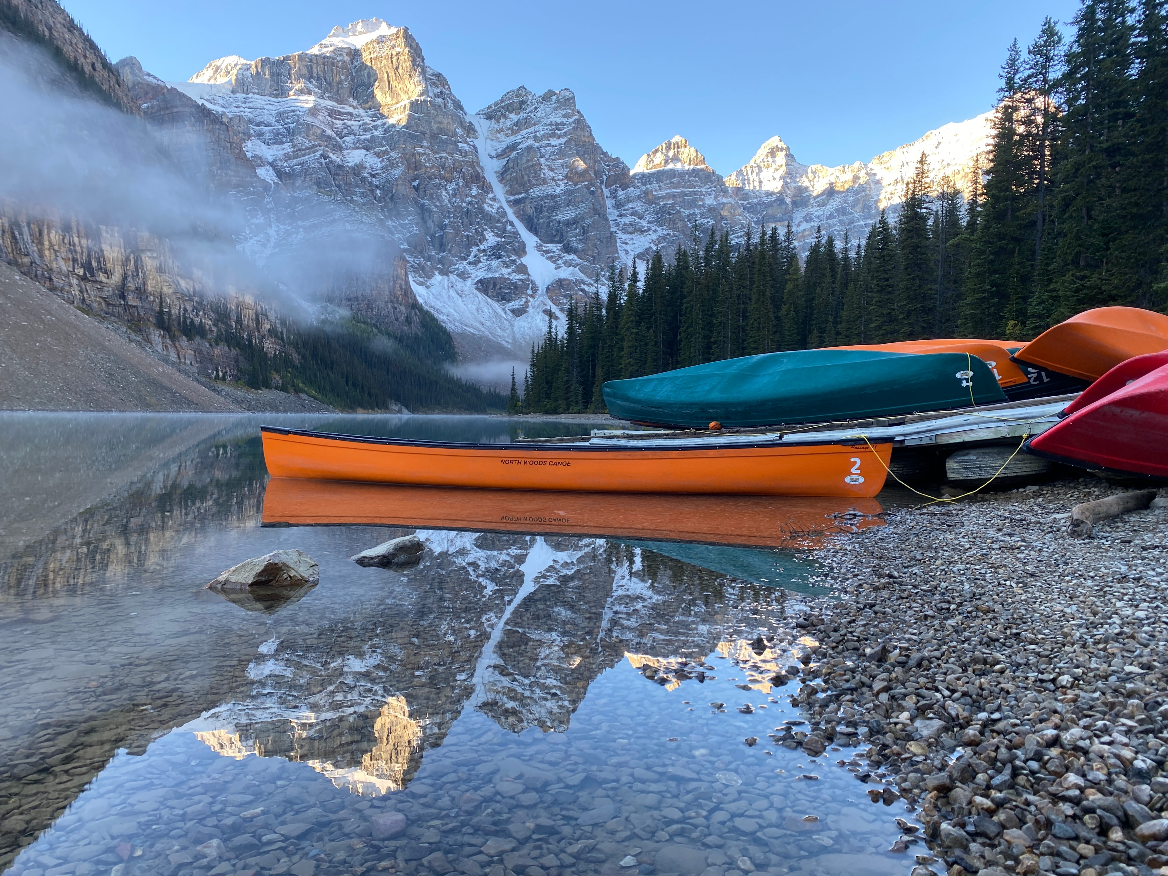 Colourful canoes on a mountain lake at sunrise, Canadian Rockies